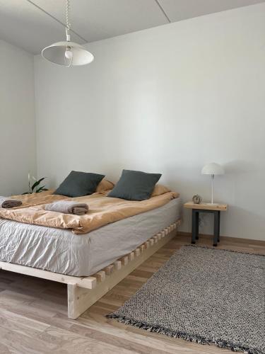 um quarto com uma cama grande num quarto branco em Tyylikäs saunallinen huoneisto Sotkamon satamassa em Sotkamo