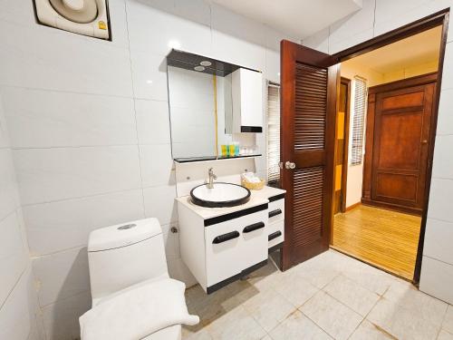 biała łazienka z toaletą i umywalką w obiekcie Butterfly Valley w mieście Ban Na Phoc Thap