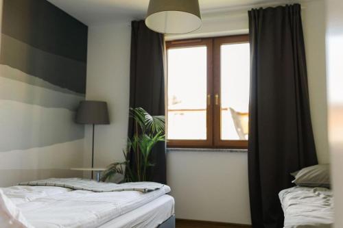 a bedroom with a bed and a window at Villa Monica Apartamenty in Szczyrk