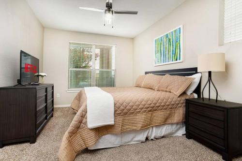 a bedroom with a bed and a dresser and a television at Private 2BR APT Downtown By RiverWalk in San Antonio
