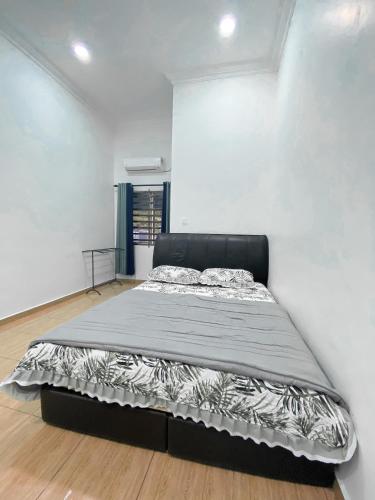 a bedroom with a large bed in a white wall at Bauk View Homestay in Batu Lima