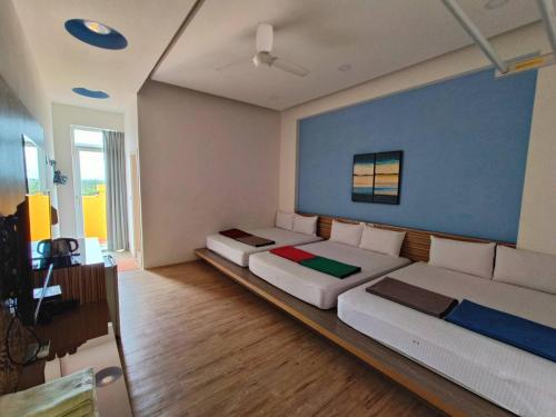 a large bedroom with two beds and a blue wall at Moumoon B&B in Magong