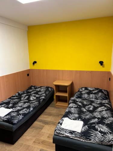 Pokój z 2 łóżkami i żółtą ścianą w obiekcie Penzion u Fika w Ostravie