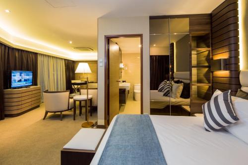 a hotel room with a bed and a living room at Republic of Singapore Yacht Club in Singapore
