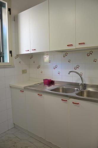a kitchen with white cabinets and a sink at Villa Teti - Sicilia in Campofelice di Roccella