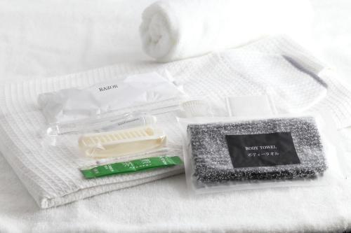 a package of toothpaste and a toothbrush on a towel at Henn na Hotel Premier Nagoya Fushimiekimae in Nagoya