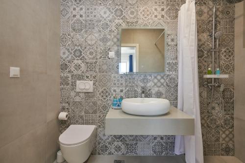 bagno con lavandino, servizi igienici e specchio di Apartments Endji a Čilipi