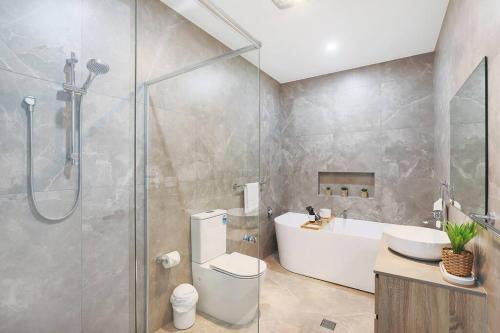 uma casa de banho com um chuveiro, um WC e um lavatório. em Illalangi-Modern Escape & Views em Mudgee