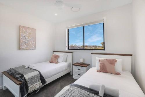 um quarto com 2 camas e uma janela em Illalangi-Modern Escape & Views em Mudgee