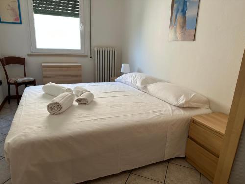維洛納的住宿－Casa Bauli，一张白色的床,上面有两条毛巾