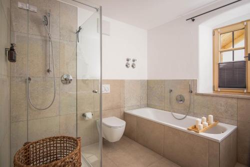 a bathroom with a shower and a tub and a toilet at MY STAY- Erholung zwischen See und Bergen, neu erbaute Apartments im modernen Landhausstil mit Bergblick, familienfreundlich in Fischbachau