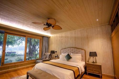 een slaapkamer met een bed en een plafondventilator bij Riverside French Villa in Thuan An