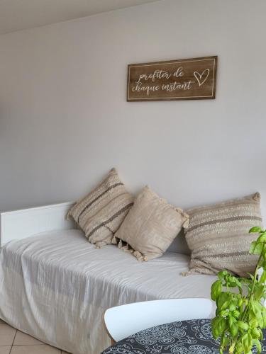 - un canapé blanc avec des oreillers et un panneau mural dans l'établissement Au bord de l'eau rend la vie à Arcachon, à Arcachon