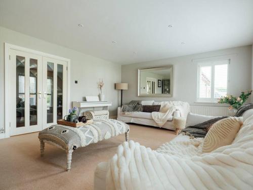 a living room with white furniture and a couch at The Paddock - Luxury 5 Bed with Swimming Pool! in Ombersley