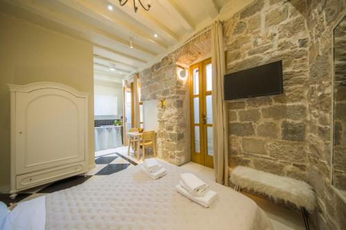 - une chambre avec un lit et un mur en pierre dans l'établissement Hidden Luxury Residence 2BR with terrace, à Split