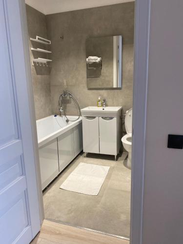 a bathroom with a sink and a tub and a toilet at Aktau Riviera Актау in Aktau