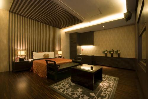 a hotel room with a bed and a chair at Harport Motel in Niaosong