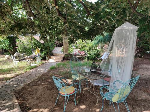 a table and chairs sitting under a tree at Stone house with seaview in Nea Potidaea