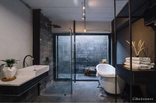 a bathroom with a tub and a sink and a shower at Bedsment in Chiang Rai