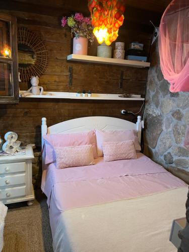 a bedroom with a bed with pink sheets and pillows at Chalet Valdevaqueros - Gran piscina y 5 min playa in Tarifa