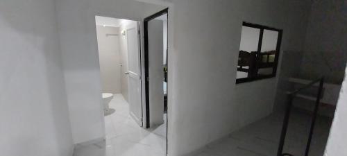 Baño blanco con espejo y aseo en LA MEDELLIN HOSTAL en Cartagena de Indias