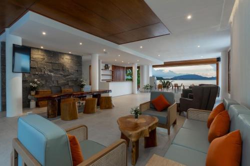 X-Sea Khanom Harbor Bay Resort في خانوم: غرفة معيشة مع أريكة وطاولة