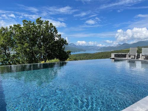 a swimming pool with a view of the mountains at Les Restanques du lac in La Chapelle