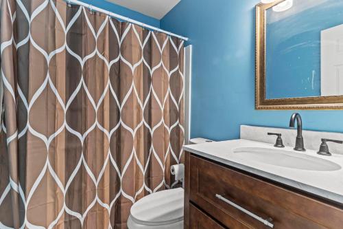 a bathroom with a toilet and a sink and a mirror at Shore Oasis in Seaside Heights