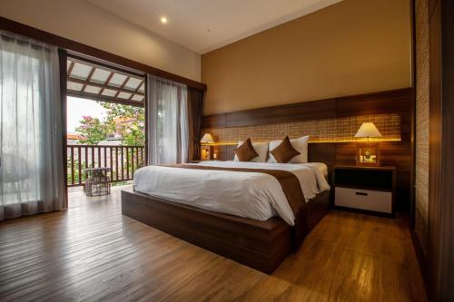 sypialnia z dużym łóżkiem i balkonem w obiekcie Ratan Hotel Uluwatu w mieście Uluwatu