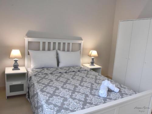 ein Schlafzimmer mit einem Bett mit zwei Nachttischen und zwei Lampen in der Unterkunft Maria's Central Renovated Suites 2 in Alexandroupoli