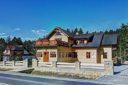 a large wooden house on the side of the road at Noclegi Styrnol & SPA in Zawoja
