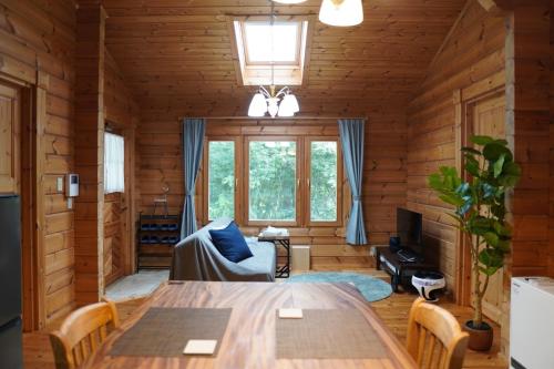 a dining room with a table in a log cabin at ＯＮＶＯ ＳＴＡＹ ８ in Hokuto