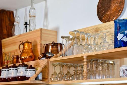 drewniana półka ze szkłami i innymi wyrobami szklanymi w obiekcie Ижата - топлина и уют w mieście Borovitsa