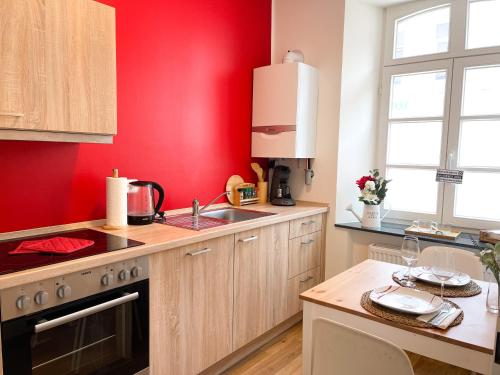 a kitchen with red walls and a counter top at Praktisch & modern - voll ausgestattetes Apartment in Stolberg