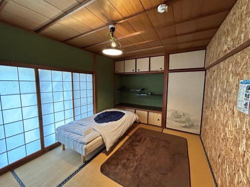 1 dormitorio con 1 cama en una habitación con ventanas en heso house, en Miyoshi