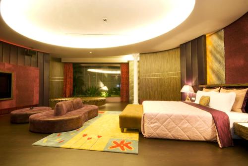 a bedroom with a bed and a living room at Harport Motel in Niaosong
