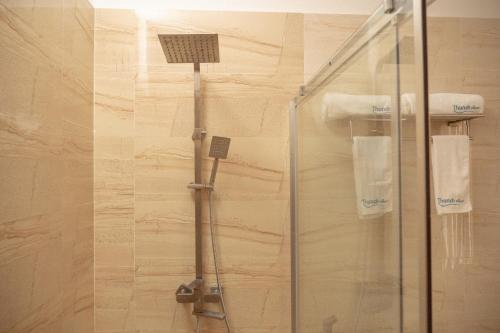 a shower with a glass door in a bathroom at Thundi Village & Spa in Maalhos