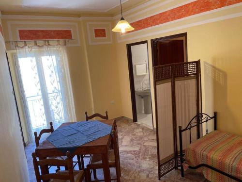 a room with a table and a bed and a window at U Curtigliu apartment in Realmonte