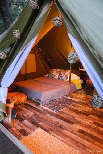 une tente avec un lit au milieu dans l'établissement TENTE HERISSON BOHEME 4 PERSONNES Camping Lou cantou Cévenol, à Anduze