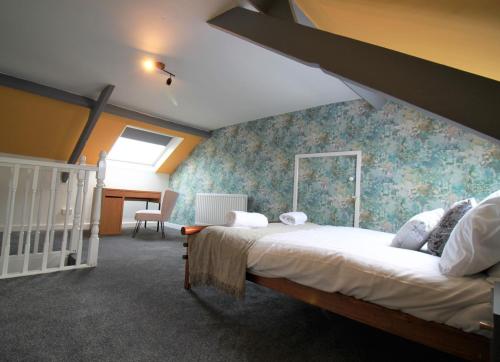 een slaapkamer met een bed en een blauwe muur bij Westbourne - Spacious 4 bed flat with free parking in Gateshead