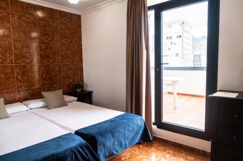 a bedroom with a bed and a large window at Hotel Adonis Capital in Santa Cruz de Tenerife