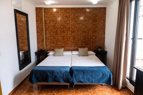 a bedroom with a large bed with a blue blanket at Hotel Adonis Capital in Santa Cruz de Tenerife
