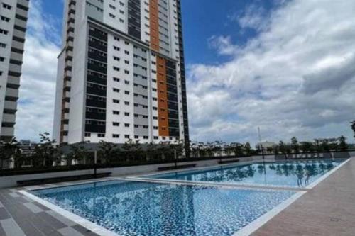 a swimming pool in front of two tall buildings at Alanis Residence@KLIA in Sepang