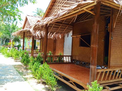a house with a thatched roof with a porch at New Andaman Bay Bungalow in Ko Lanta