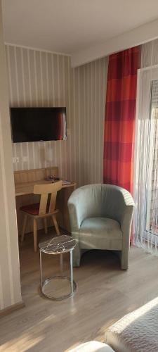 a living room with a couch and a chair and a table at Hotel Wurster Kroog in Bremerhaven
