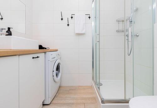 a bathroom with a shower and a washing machine at CITYSTAY Starówka Apartament in Gdańsk