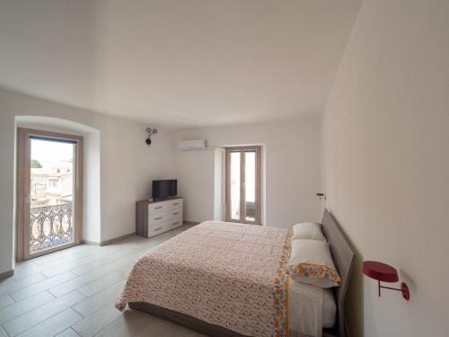 Habitación blanca con cama y ventana en Villa Ecclesiae en Iglesias