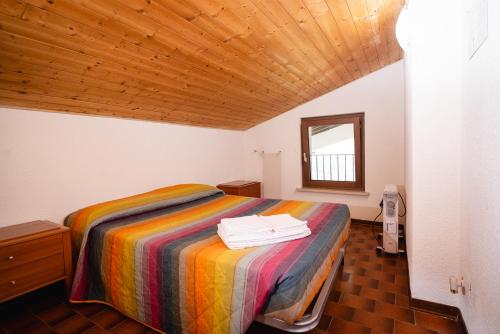 a bedroom with a bed with a colorful blanket at Villa tra montagna e laghi 14 posti in Crone