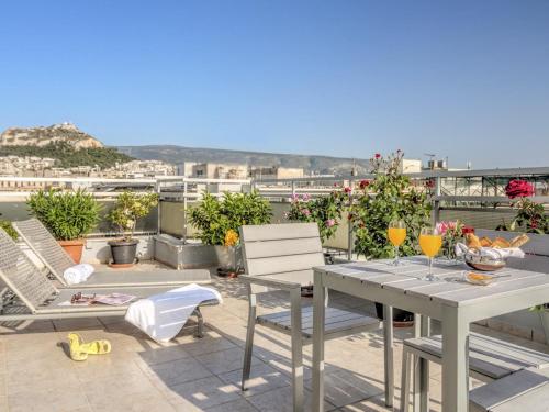a patio with a table and chairs on a roof at Polis Grand Hotel in Athens