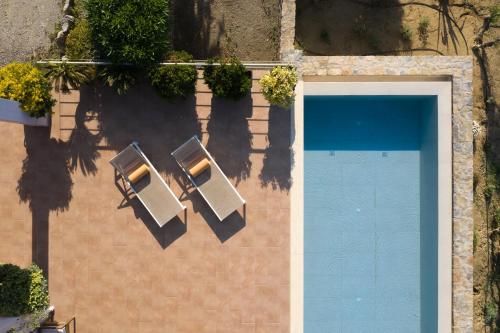 an overhead view of a swimming pool with two chairs at Sunrise Villa, a Secluded Gem in South Crete, By ThinkVilla in Marioú